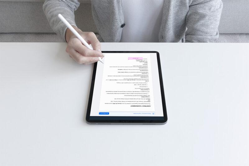 photo of a person signing a contract that is managed in the document and contract signing feature in Hi5 Connect